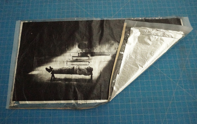 実際にプリントされた雁皮紙の裏面には銀箔が裏打ちされている。これをトリミングして台紙に貼り完成。銀箔の効果で見る角度によりハイライトが妖しく光り、独特の不思議な存在感のプリントになる