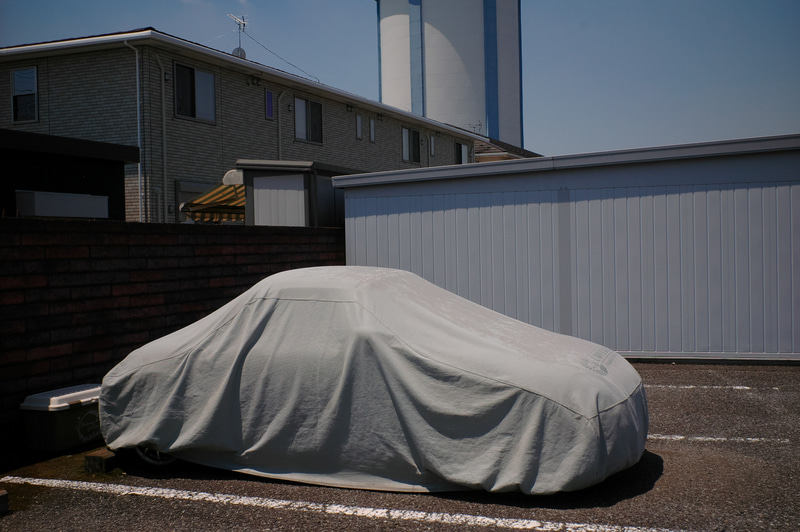 気持ちだけはロバート・フランクなので、車にカバーがかけてあると必ず撮影することになっております。球面レンズのウルトロン28mm F2を使用していますが、R-D1との相性は最高で、シャープネス、コントラスト、階調の出方も素晴らしいです。<br>R-D1　ULTRON 28mm F2（F11・1/1,400秒）ISO 400