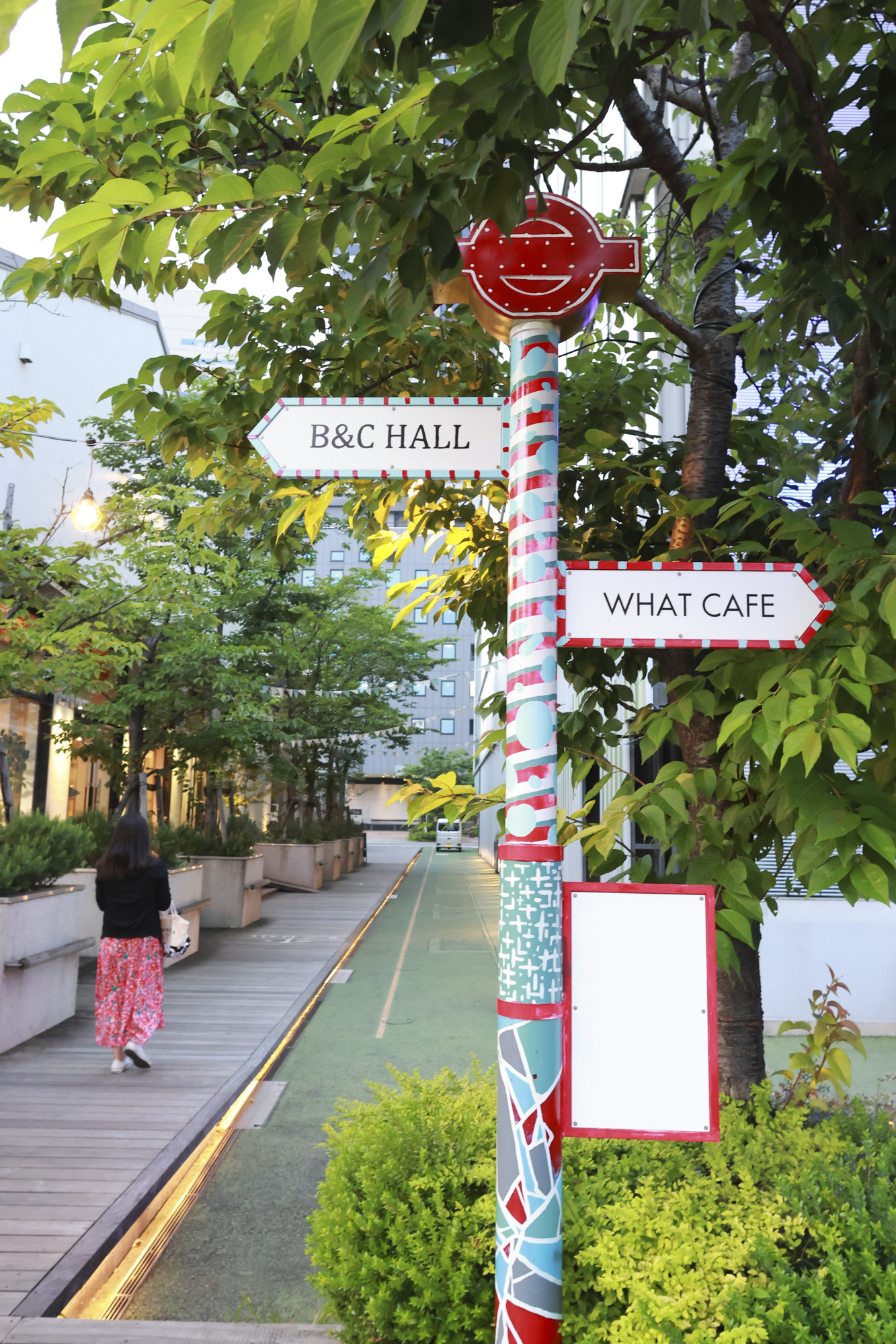 カラフルなポールサインと雰囲気がマッチするスカートの女性が通りがかった。とっさのタイミングでも逃さず撮影できるのはR7のスピードがあってこそだ<br> <span class="fnt-85">RF16mm F2.8 STM／16mm（26mm相当）／プログラムAE（F4、 1/80秒、+1.3EV）／ISO 3200／WB:オート</span>