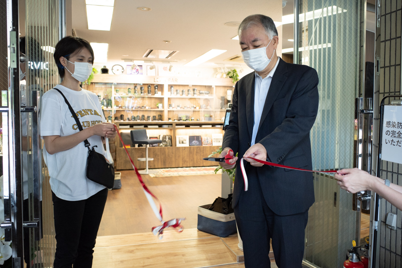 オープン前から列をなすファンが見守る中、テープカットを行ったリコーイメージング赤羽社長