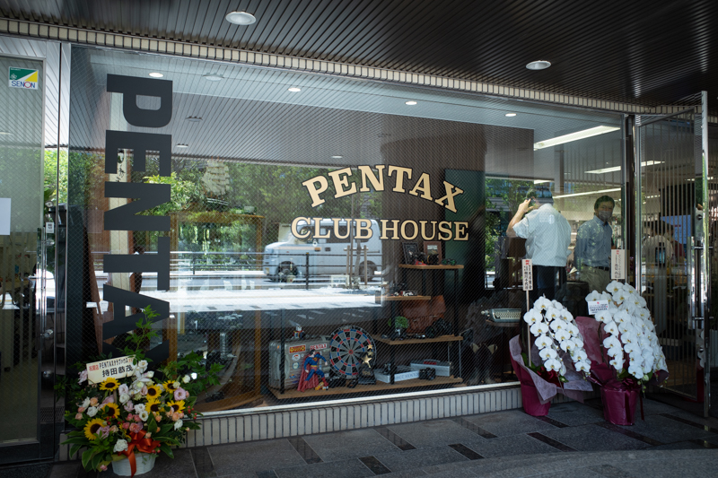 道路から見たPENTAXクラブハウスのショーウインドウ。様々なアイテムが雰囲気たっぷりに並んでいる。J limitedが初お披露目されたCP+2019の同社ブースを思い出した
