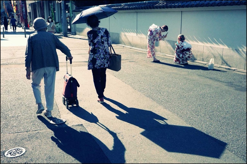 ワイドレンズだと奥行きが付きすぎて、手前の二人を切るか、奥の二人を小さく扱うか、二択になってしまう。レイヤー的という言い方をすることが多いが、距離の違う被写体を対比して撮るような場合に40mmは最適<br><span class="fnt-85">GR IIIx　プログラムAE（F8・1/125秒）ISO 400／レトロ</span>