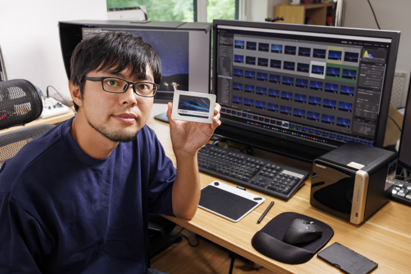 筆者の中原一雄さん。手に持っているSSDがNASのストレージとして使用したCrucial MX500