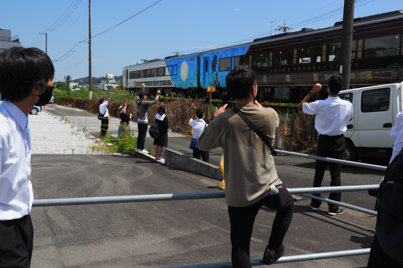 観光列車に手を振る一行