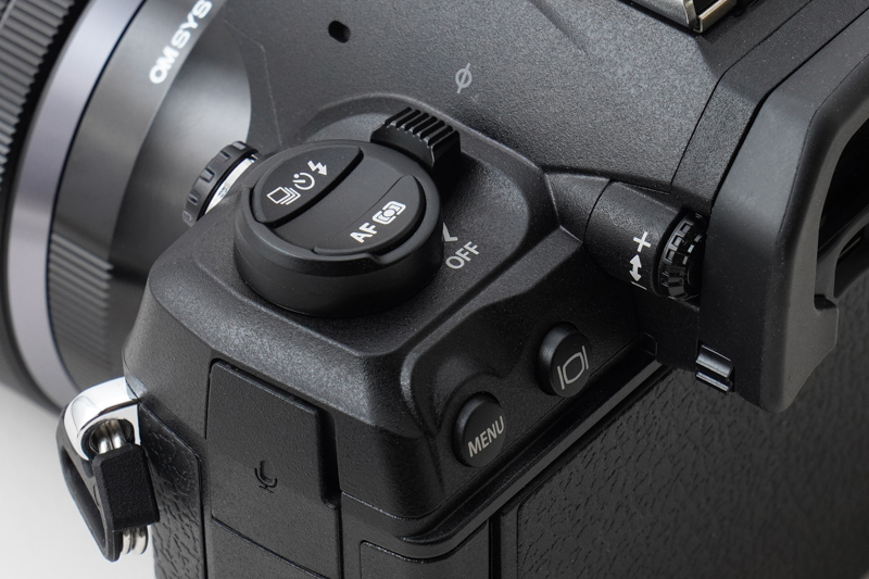 造形にこだわりを感じさせる、凹形状の「AF/測光モードボタン」と「連写/セルフタイマー/フラッシュボタン」、および「ON/OFFレバー」。