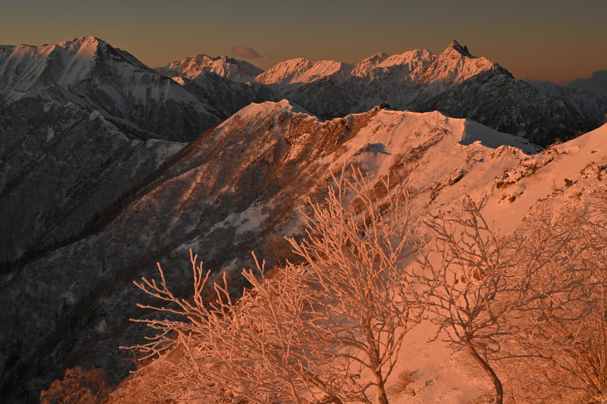 前日の吹雪が収まり、新雪で化粧直しした槍・穂高連峰がモルゲンロートに染まり始めた。カメラを三脚に固定し、染まる光に合わせて素早く構図を決めて撮影した<br><span class="fnt-85">Nikon Z 7／NIKKOR Z 24-70mm f/2.8 S／46mm／マニュアル露出（F14、1/40秒）／ISO 200／WB：日陰</span>
