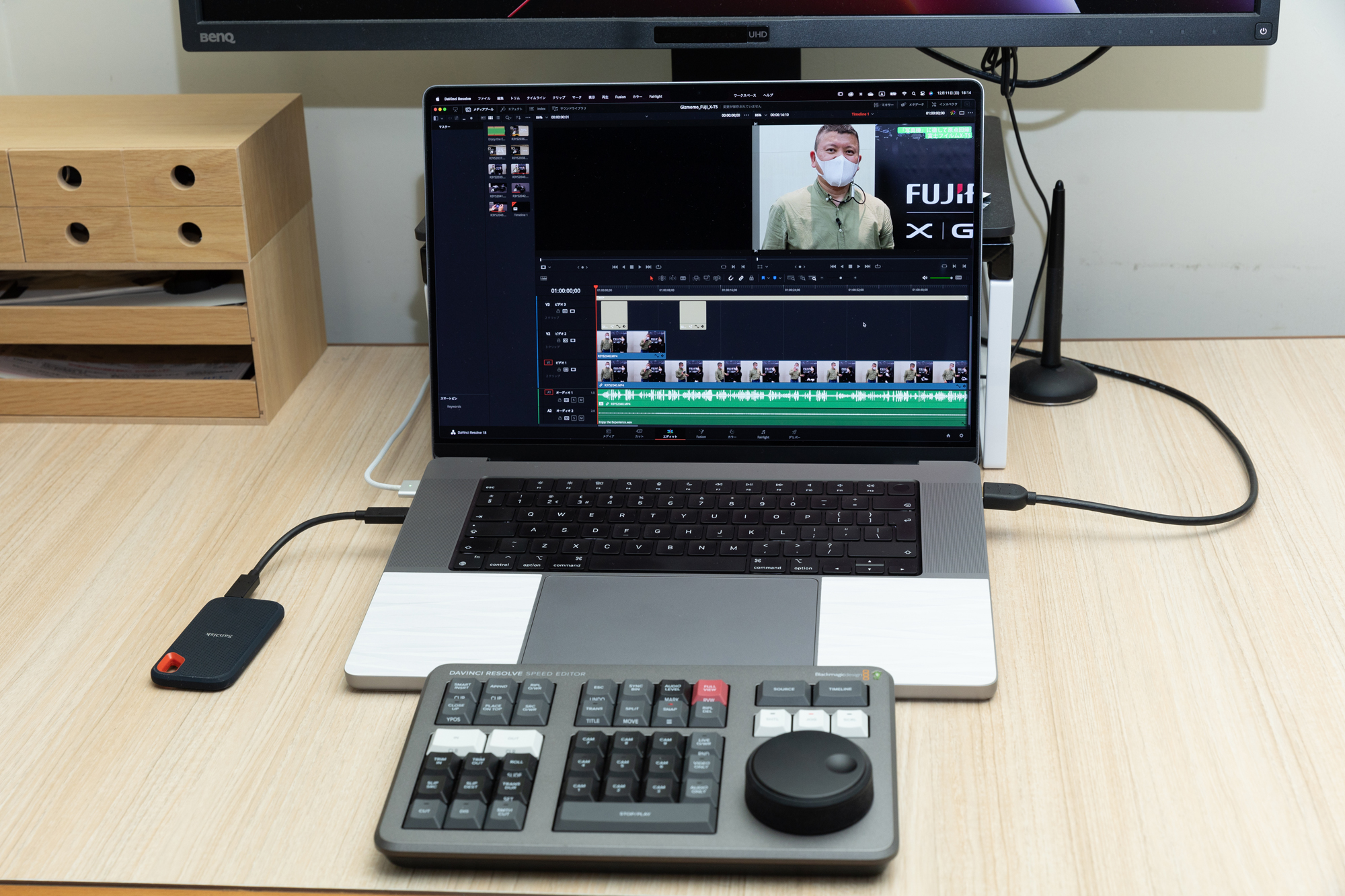 個人事務所での使用環境。16インチMacBook Proにビデオ編集アプリは「DaVinci Resolve Studio 18」。外付けSSDとしてSanDisk Extreme SSD 2TB、編集コンソールとしてBlackmagic SpeedEditor。画質チェックはしないタイムライン表示用にBenQの32型デザイナー向けモニターPD3200Uを使用している