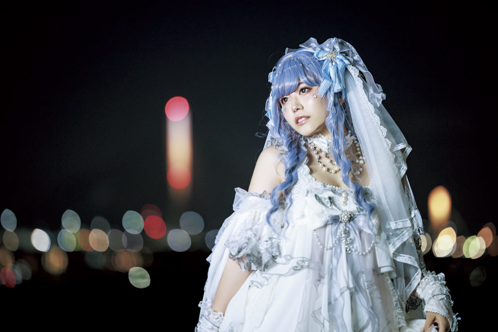 対岸の街夜景を玉ボケとして表現したかったのでF値は開放F1.8にしている。2灯のフラッシュで明るさをサポートすることで表情と衣装のディテールをはっきり見せることに成功した<br><span class="fnt-85">キヤノン EOS R6 Mark II／RF135mm F1.8 L IS USM／135mm／マニュアル露出（F1.8、1/100秒）／ISO 4000／WB：5,000K／EL-5×2灯</span>