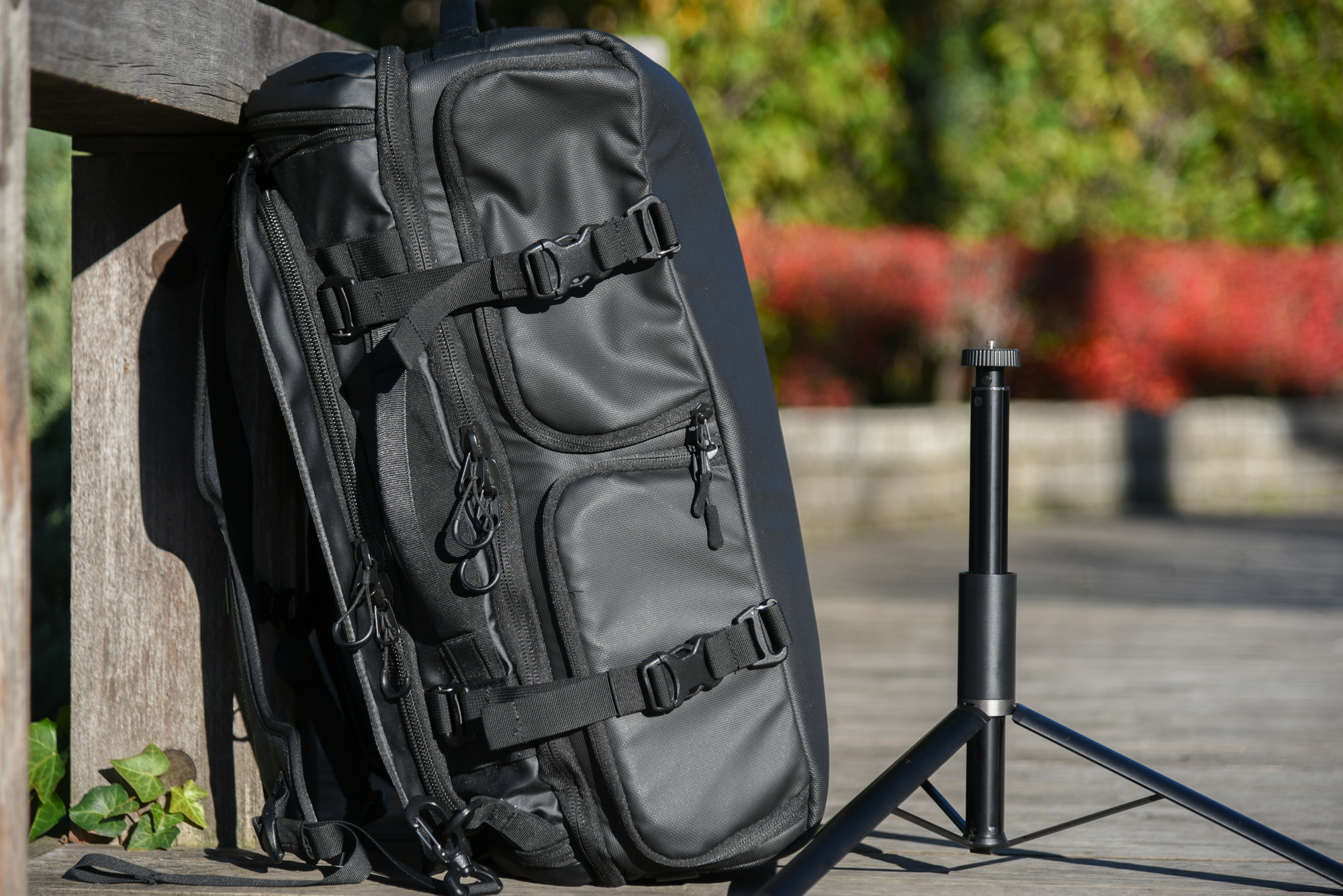 バッグを背負ったときに左側に来るこっちサイドの見た目に唯一無二感があってよいです。右に置いてあるのは全伸長170cmになるスタンドで、このバッグに入れてよく取材に行きます。バッグ自体のサイズは22.5×55×35cmなので、小さくたためるスタンドや三脚を収納できるのもポイントです