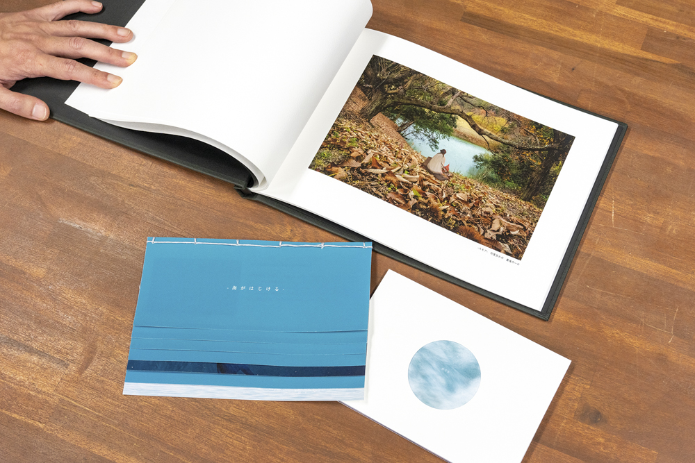 今回制作した3冊の「フォトブック」。上は高級感漂うハードカバータイプ。左下が和綴じのタイプで。右下は川本さんが「ベーシックタイプ」と呼ぶ無線綴じの「フォトブック」