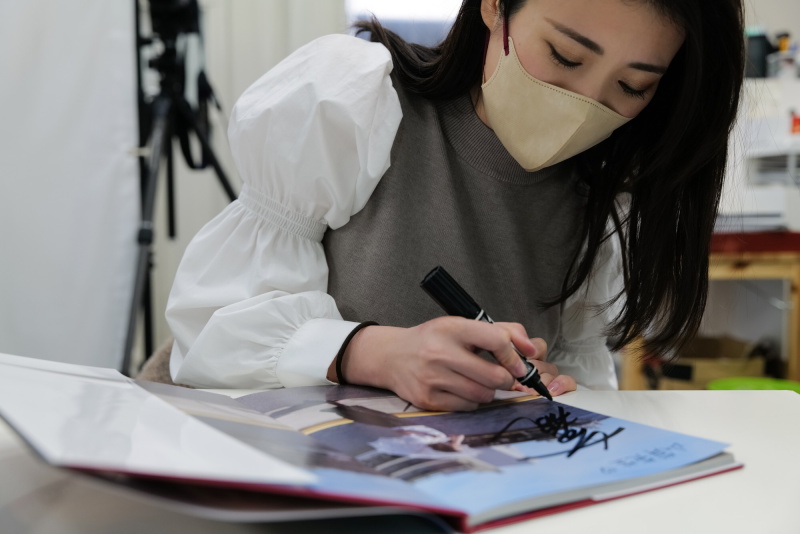 でき上がった2nd写真集にサインを入れてもらいながら当時を振り返る