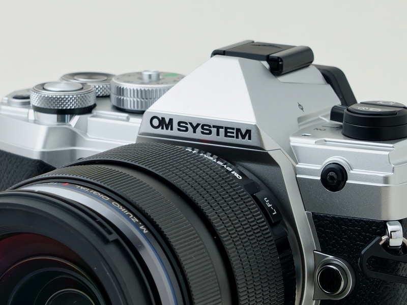 ペンタ部風のセンターファインダー部に燦然と彫り込まれた「OM SYSTEM」のブランドロゴ。トンガリ帽子がオリンパス継承のカメラらしい！