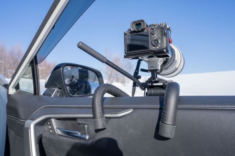 窓を開けてドアにフックをかけて使用する。前後で荷重を分散してカメラをしっかりと固定することができる