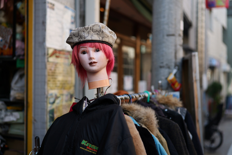 古着屋さんの店頭ですね。黙っていても、カメラはマネキンの首にフォーカスしました。合焦点は素晴らしい再現。ボケは少し重たいかなあという程度でしょうか。<br>LUMIX S5II／LUMIX S 50mm F1.8／絞り優先AE（F2・1/2,500秒）／ISO400