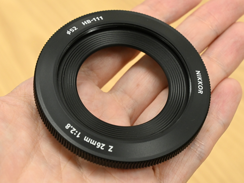 付属のフード。バヨネット式で取り付ける。前面に52mmのフィルターネジが備わる