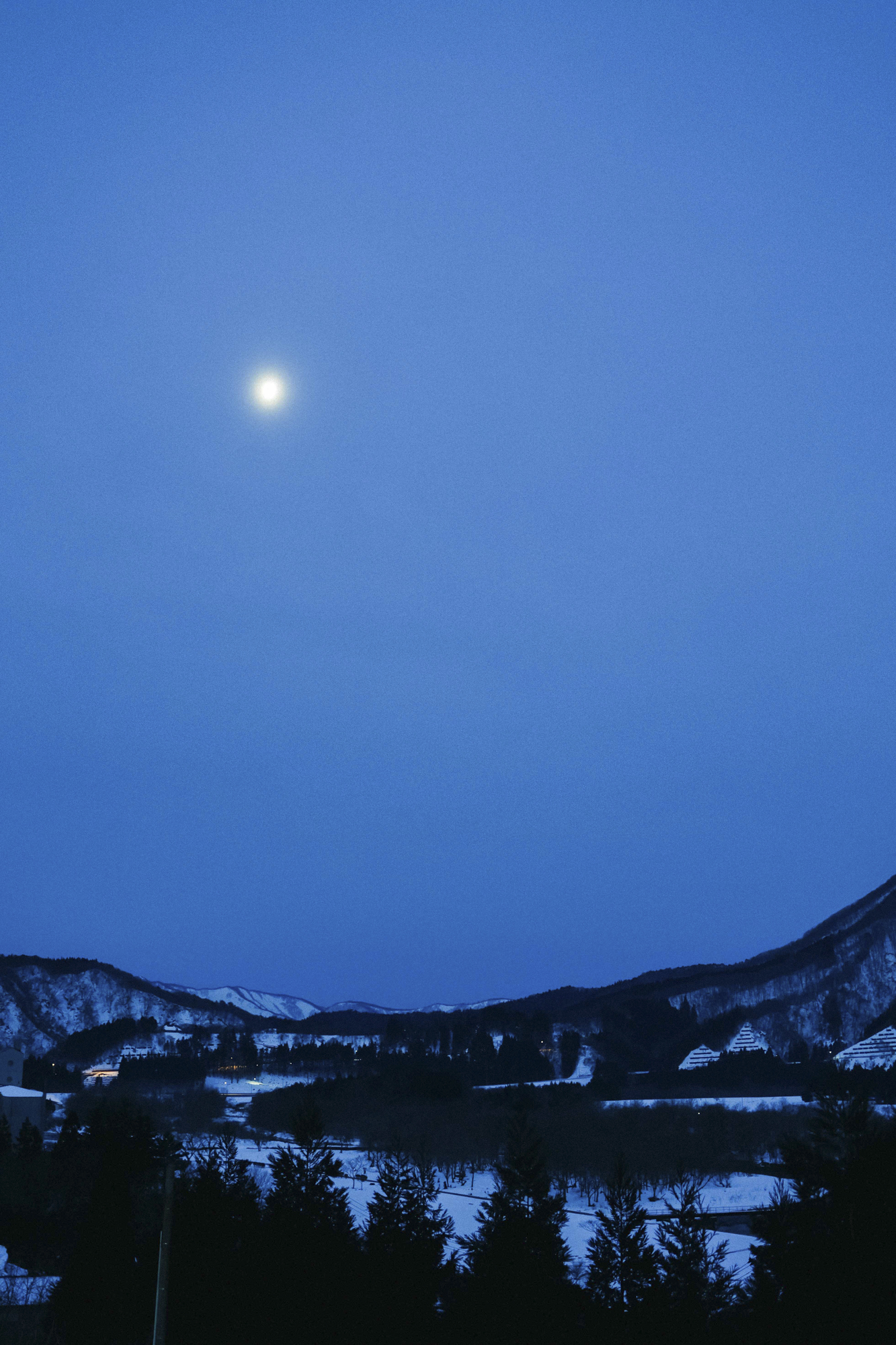 宮城の早朝。月が雪の地上を照らしている様子が美しかった。まだ薄暗く、絞りを開け気味で撮影したが、遠景まで十分に描写してくれた。EOS R8の高感度性能と組み合わせれば暗いシーンの撮影がしやすい<br><span class="fnt-85">EOS R8／RF35mm F1.8 MACRO IS STM／35mm／マニュアル露出（F2.5、1/40秒）／ISO 1250／WB: 4300K</span>