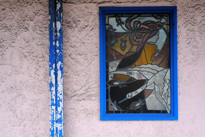 古いバーのステンドグラスです。店のファサードのために下方が明るく上部が暗いという悪条件です。階調のつながりもよく、カメラとレンズが双方で協力して頑張って再現している印象です。<br>X-E4／NOKTON 23mm F1.2 Aspherical／絞り優先オート（F4・1/640秒）／ISO400