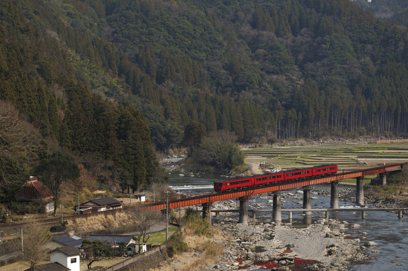 日本的な風景が広がるこの場所は、どの画角で切り取るかを迷う。超望遠側で鉄橋メインでも良いが、列車の顔が影になるのが目立つ。100mmから400mmまで幅広い焦点域を持つズームレンズは構図を細かく調整できて非常に便利だ<br><span class="fnt-85">EOS R8／RF100-400mm F5.6-8 IS USM／113mm／マニュアル露出（F6.3、1/1,250秒）／ISO 800／WB：オート</span>