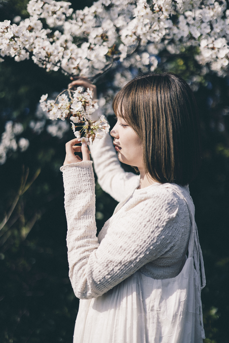 桜の位置と顔の位置を同じラインで撮影。RF50mｍは口もとにかかる桜の影まで鮮明に捉えてくれた。ややローポジションでの撮影だったが、軽量レンズとバリアングルモニターのおかげで難なく撮影ができる<br><span class="fnt-85">EOS R8／RF50mm F1.8 STM／50mm／マニュアル露出（F2、1/4,000秒）／ISO 100／WB：オート</span>