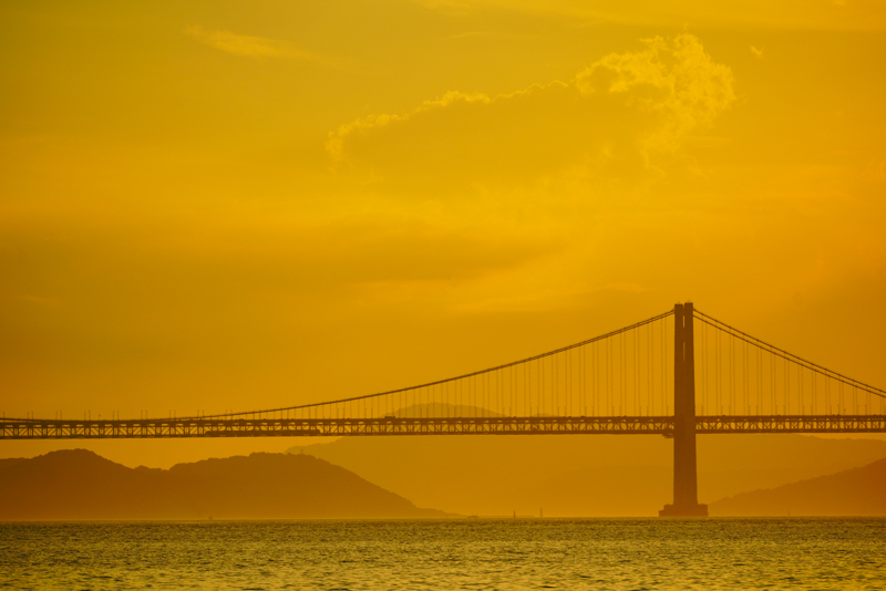 瀬戸大橋では、列車は自動車道の下を走るので、背景が明るくなる夕方にシルエットで狙うのがポイントです。作例を見ればわかるように、列車はかなり小さくても目立つので、風景を大きく入れて撮影するのがオススメです。それにしても、瀬戸大橋を見るたびに人類の技術ってスゴいなぁ……と、感心してしまいます。僕は撮影したことがありませんが、2月と10月の年2回、瀬戸大橋を渡る列車と夕日を重ねて撮影できるそうです。いつかチャレンジしてみたいな。（瀬戸大橋線 児島〜宇多津）<br>ソニーα7R III／FE 100-400mm F4.5-5.6 GM OSS／絞り優先オート（265mm・F5.6・1/400秒）／ISO 200／WB:日陰 <a href="https://goo.gl/maps/6Hth8EKWe5VmbRmt6" class="n" target="_blank">[Google Maps]</a>