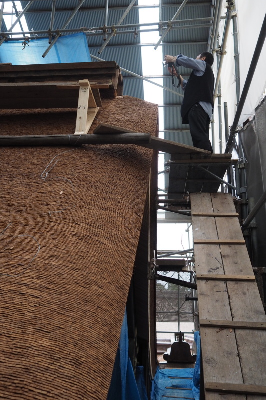 葺き替えがだいぶ進んだ本殿の屋根。短冊状の檜の皮を幾重にも乗せる伝統工法で、軒先はかなりの厚みを持っている