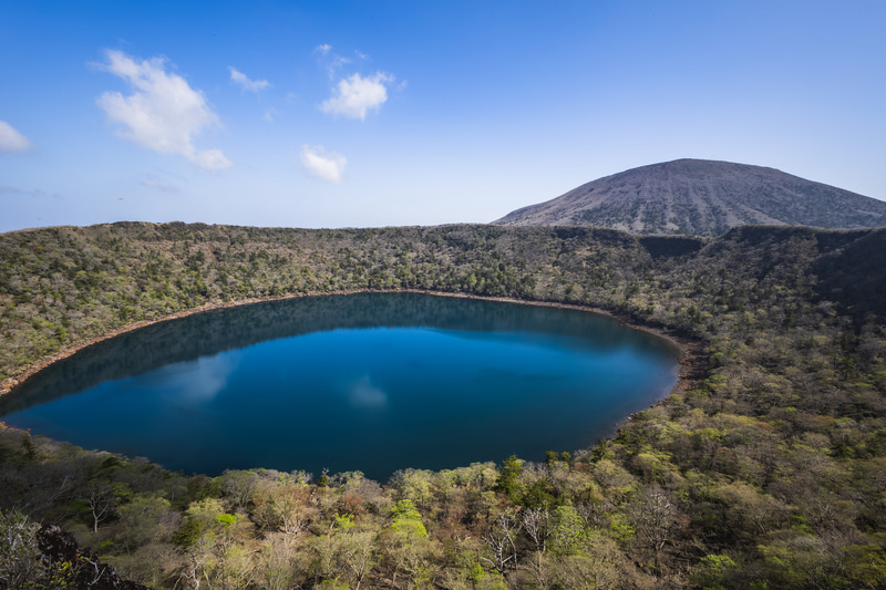 大浪池と韓国岳のどちらも入れるには超広角レンズが必須だが、RF15-30mmであればそのリクエストに対応できる。木々の1本1本も精彩な描写だ<br><span class="fnt-85">EOS R8／RF15-30mm F4.5-6.3 IS STM／15mm／プログラムAE（F8、1/200秒、±0EV）／ISO 100／WB：オート</span>