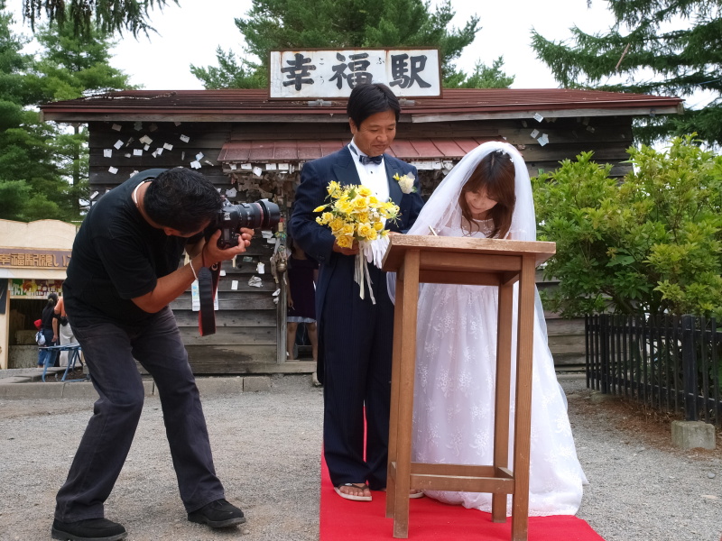 セレモニーの中で記念証を書くご夫妻