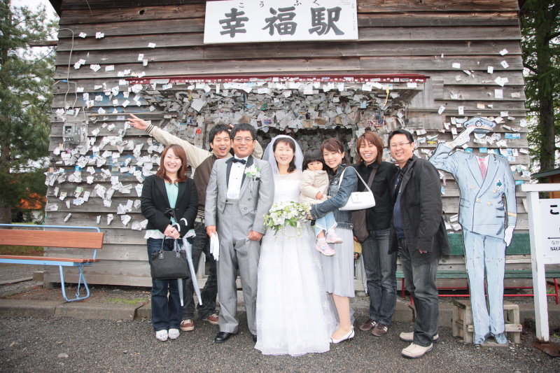 首藤さんご夫妻。背景の駅舎は2013年11月にリニューアルされる前の旧駅舎。これもまた記録である