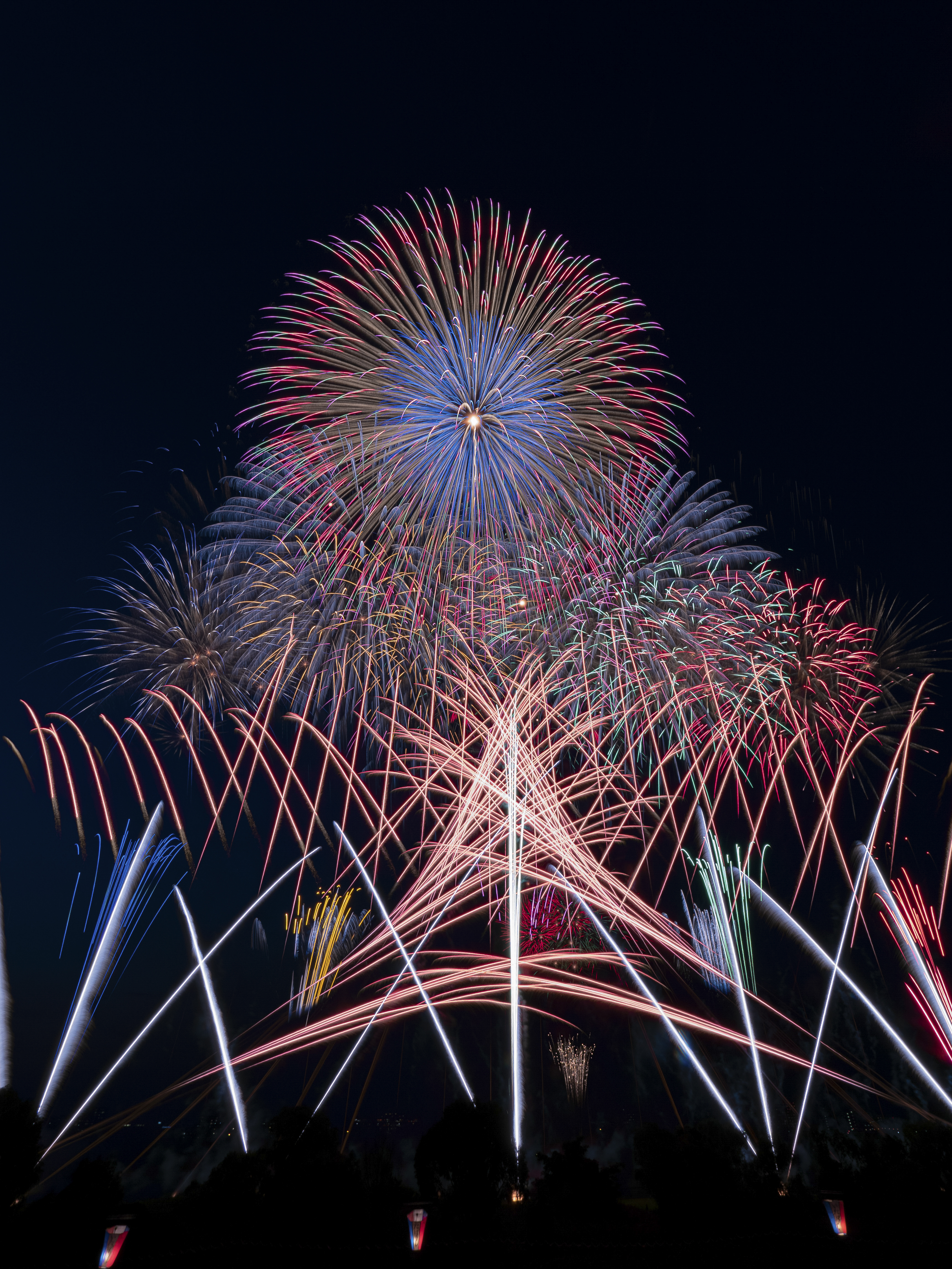 オープニングのスターマイン。低空の噴出花火とトラ花火の打上から始まり、牡丹花火と花雷、そして上空では尺五寸玉が開花する。今年はどんな打上演出になるのか楽しみだ（撮影：金武 武）<br><span class="fnt-85">PEN-F／M.ZUIKO DIGITAL ED 7-14mm F2.8 PRO／7mm（14mm相当）／マニュアル露出（0.5秒、F13）／ISO 200</span>