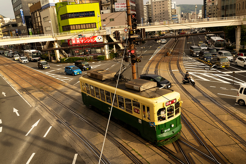 長崎市内には昔ながらの路面電車が走る。線路と道路が交差する大きな交差点に、路面電車が入ってくる姿を俯瞰で撮影した。小型なパンケーキレンズとの組み合わせならタイミングを合わせてシャッターが切れる<br><span class="fnt-85">EOS R8／RF28mm F2.8 STM／28mm／マニュアル露出（F8、1/200秒）／ISO 100／WB：くもり</span>