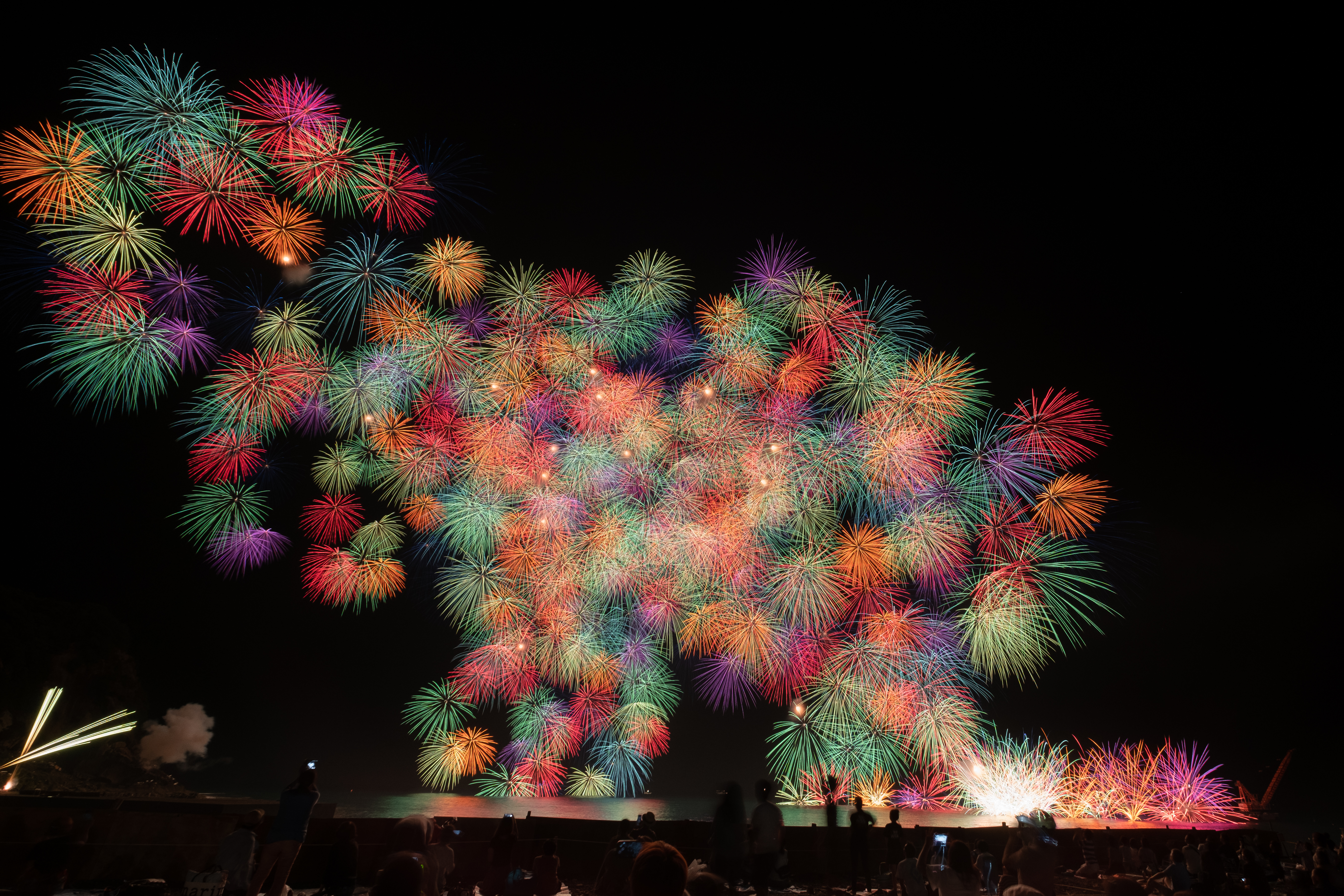 小さな花火が一斉に開く千輪菊花火を数発同時に開花させている。打上音を聞いていると開花するタイミングがつかめるので撮りやすい花火（撮影：金武 武）<br><span class="fnt-85">X-T3／XF10-24mmF4 R OIS／10mm（15mm相当）／マニュアル露出（11.0秒、F7.1）／ISO 200</span>