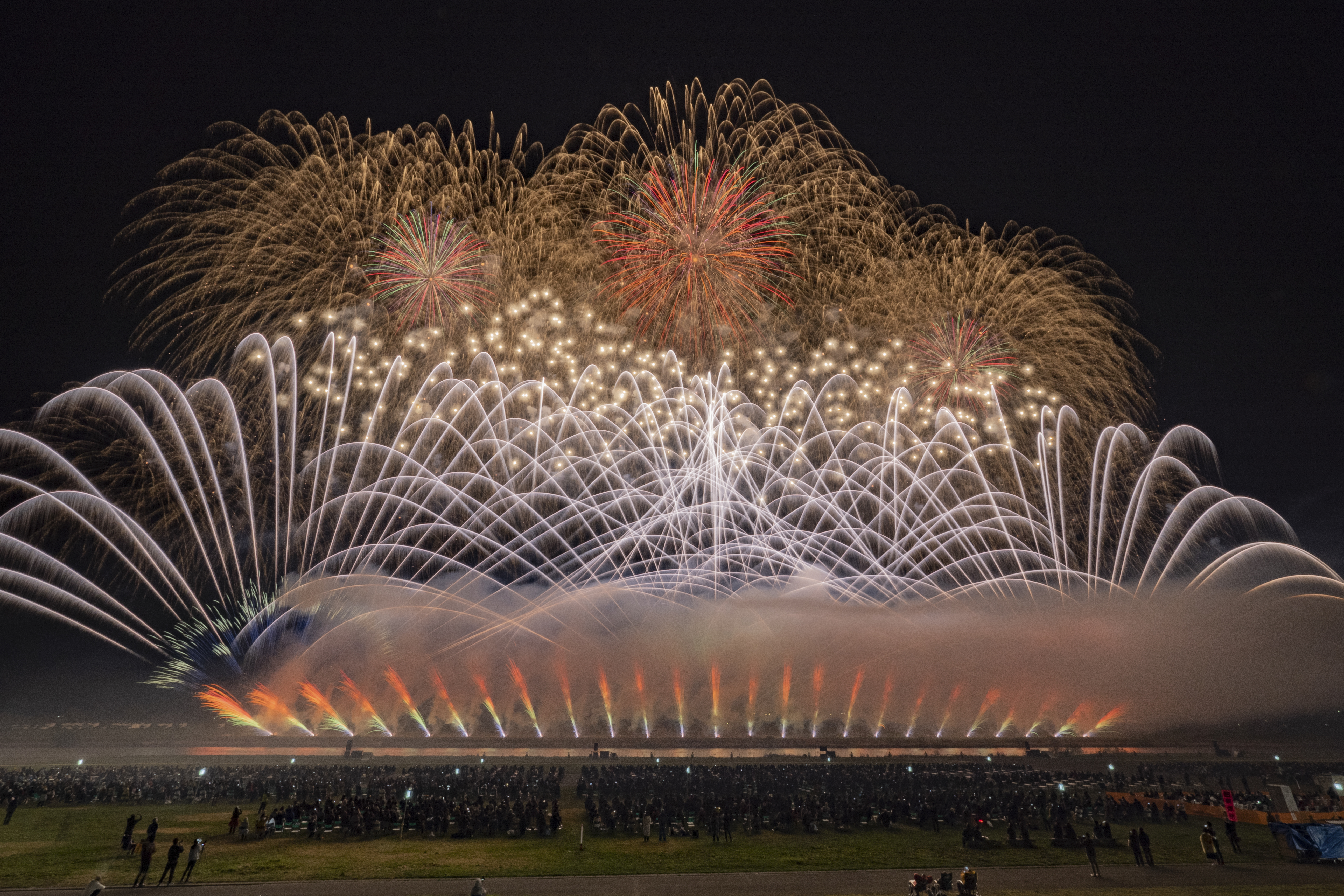 観覧席から花火打上場所までの距離は350～450mと近い。ワイドスターマインをカメラマンエリアで撮るならばフルサイズで焦点距離16mm程度は必要だ（撮影：金武 武）<br><span class="fnt-85">OM-1／M.ZUIKO DIGITAL ED 7-14mm F2.8 PRO／8mm（16mm相当）／マニュアル露出（17.0秒、F16）／ISO 200</span>