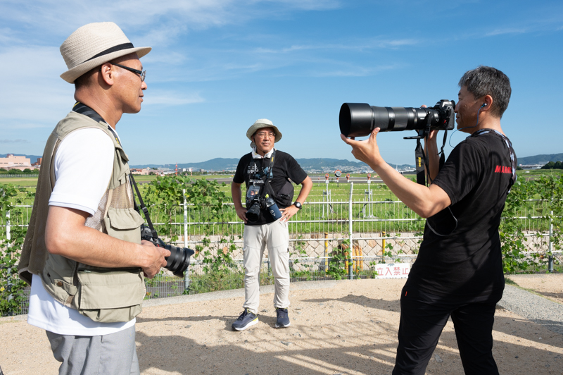 「こう支えると安定します」と超望遠レンズのホールド方法を教える中野さん