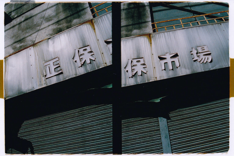 廃業した市場なんかもつい撮影しちゃうわけですが、人の気配みたいなものが残っている感じがしますぜ。もちろん単なる妄想です。画面がナナメなのは周りに人がいたので照れくさく早く撮影したかったからです<br>OLYMPUS PEN S／D.Zuiko 3cm F2.8／（F8・1/250秒）／フジカラーPREMIUM 400