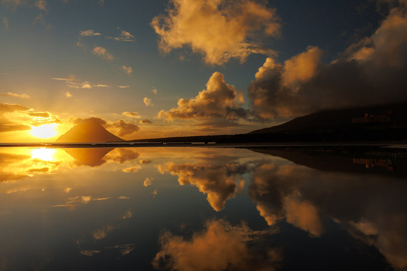 雨上がりの水たまりを使って夕焼けの空をリフレクションで切り取った。EOS R8のバリアングル液晶モニターのおかげでローポジションでの撮影も快適に行える<br><span class="fnt-85">EOS R8／RF24-105mm F4 L IS USM／24mm／絞り優先AE（F9、1/125秒、±0EV）／ISO 100／WB：オート</span>