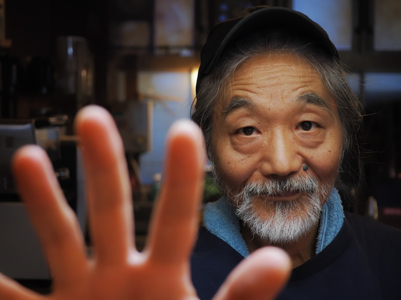 行きつけのお店のご主人の手をマクロ領域で撮らせてもらおうとレンズを向けたら、うちのOM-1くんはサッと顔に合焦しました。これ、蛍光灯下の撮影ですが、クリアです。レンズがエラいのかOM-1がエラいのか。一緒に協力したのでしょう。そんなにギスギスしたシャープネスではありません<br>OM-1／M.ZUIKO DIGITAL ED 30mm F3.5 Macro／絞り優先AE（F3.5・1/40秒・-0.7EV）／ISO 800