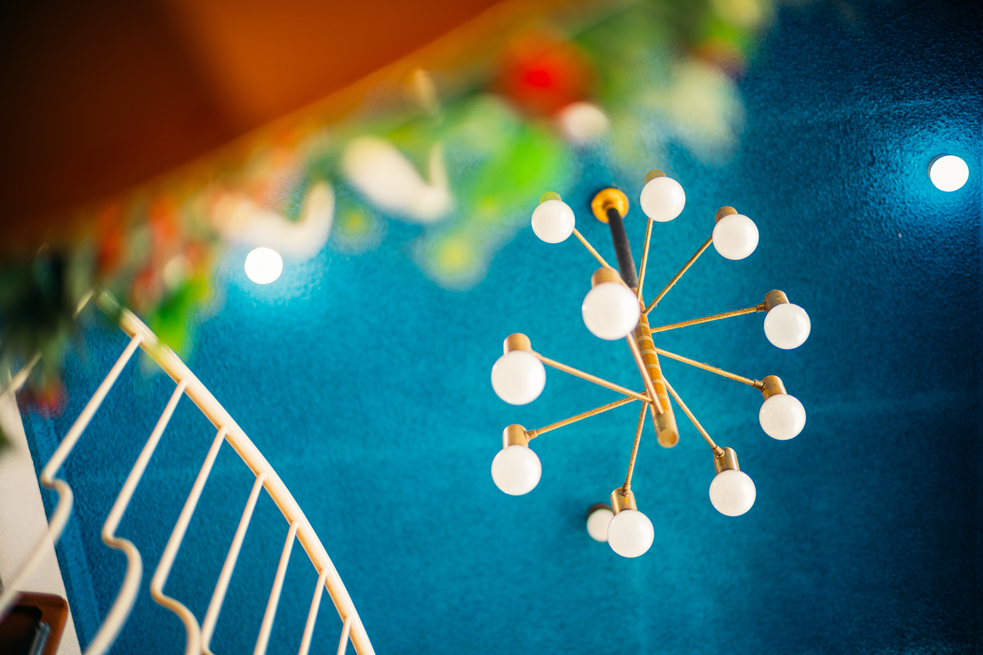 豊かな奥行きを感じられる開放F1の世界。ブルーの天井に映えるレトロな照明を主役に、それを彩るような前ボケを活かして構図を作った。大きくボケながらもピント面の描写がしっかりしているのが特徴だ<br>EOS R5／NOKTON 50mm F1 Aspherical／絞り優先AE（F1・1/80秒・+2/3EV）／ISO 100