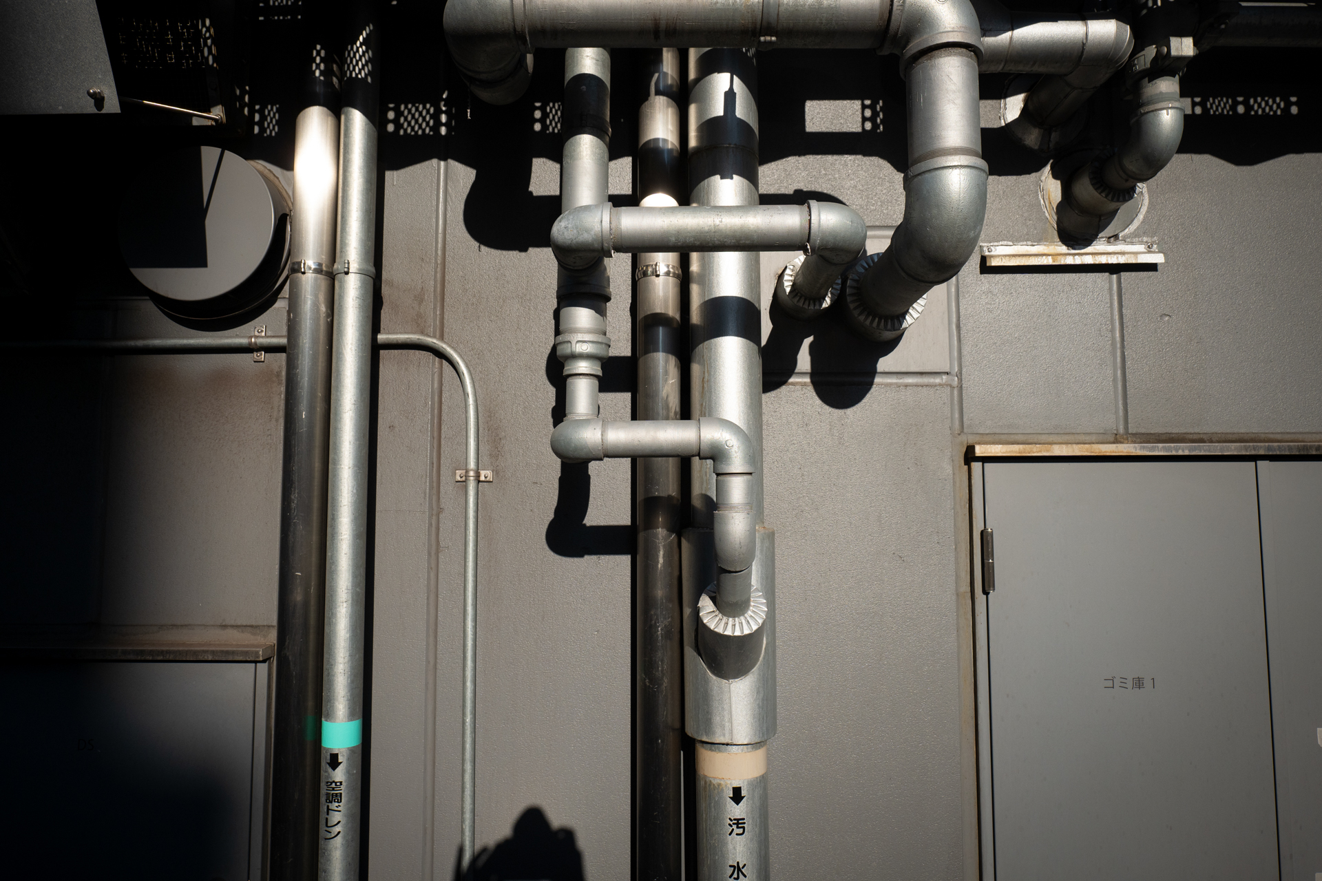グレーの世界。配管。モノトーンな風景であり、色の助けはありません。ハイライトがよい感じに描写されますね。ディテールの再現性も優れます。今度似たような被写体に出会ったらモノクロも試します<br>LUMIX S5IIX／LUMIX S 20-60mm F3.5-5.6／絞り優先AE（20mm・F8・1/2,000秒・-0.7EV）／ISO 400