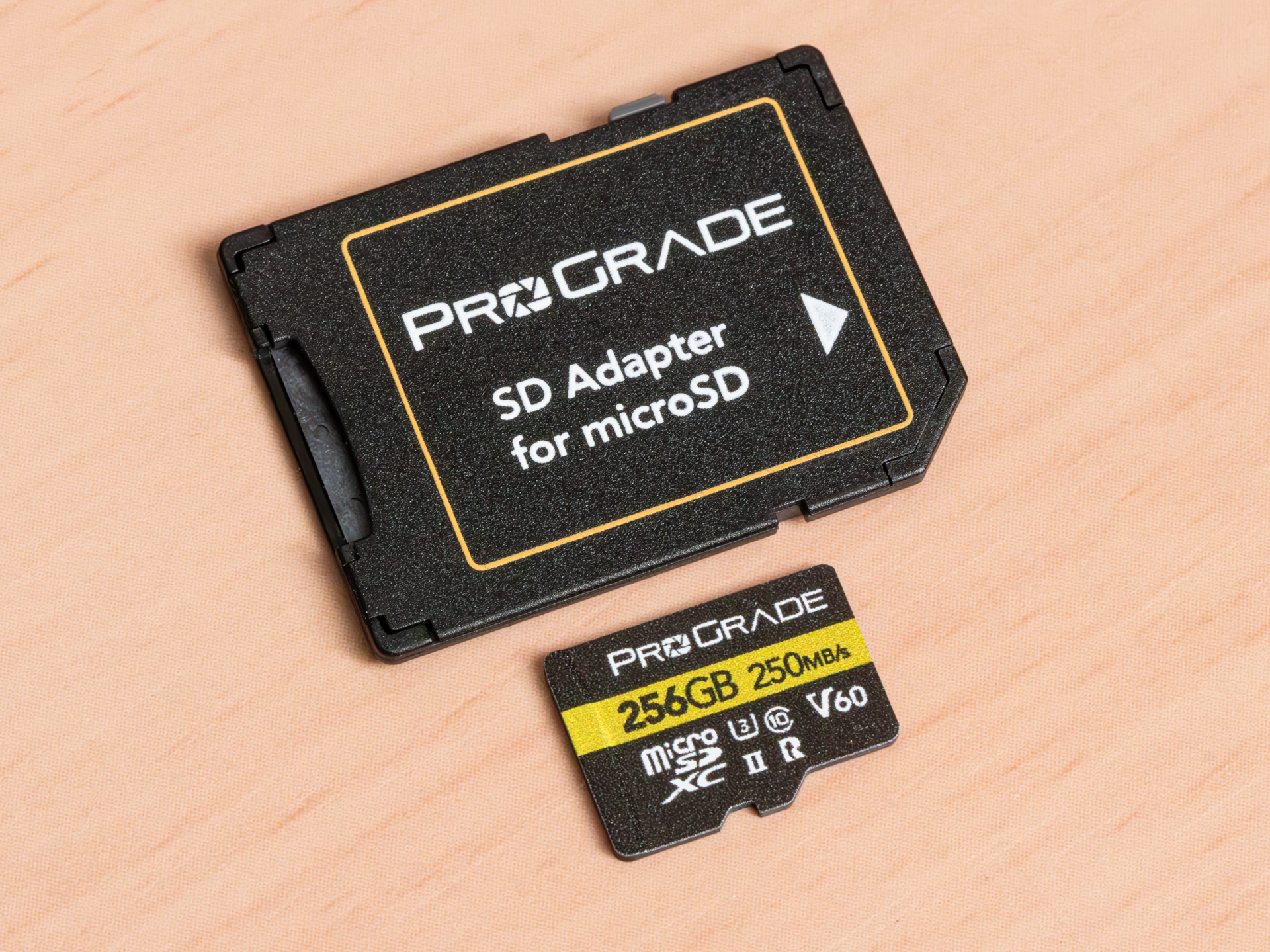 microSDXC UHS-II V60 GOLD 256GB（下）。同梱のSDカードアダプター（上）