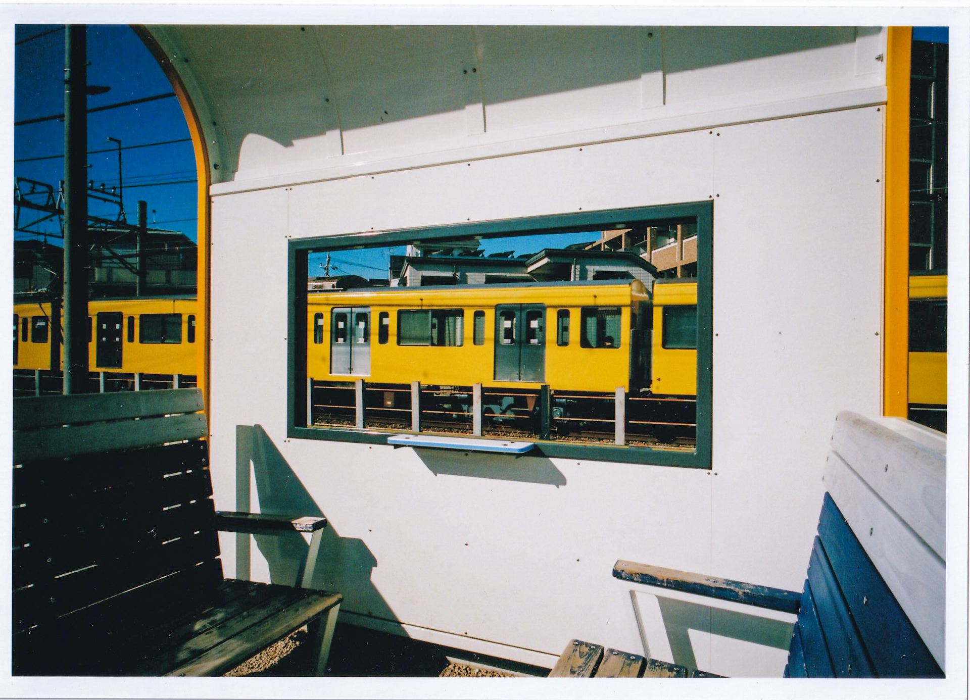 シャッターチャンスを狙うぜ、ということで走る電車の先頭の位置を狙ったのですが、RTモードで最初の遮光シャッターと補助ミラーが待避する音でシャッターを切ったと勘違いし、すぐに気づいて全押しして外した写真です。正直どうでもいいんですけど、こっちのほうがよくないですか<br>EOS RT／EF20-35mm F2.8L／絞り優先AE（20mm・F8・1/1,000秒）／フジカラーSUPERIA X-TRA 400