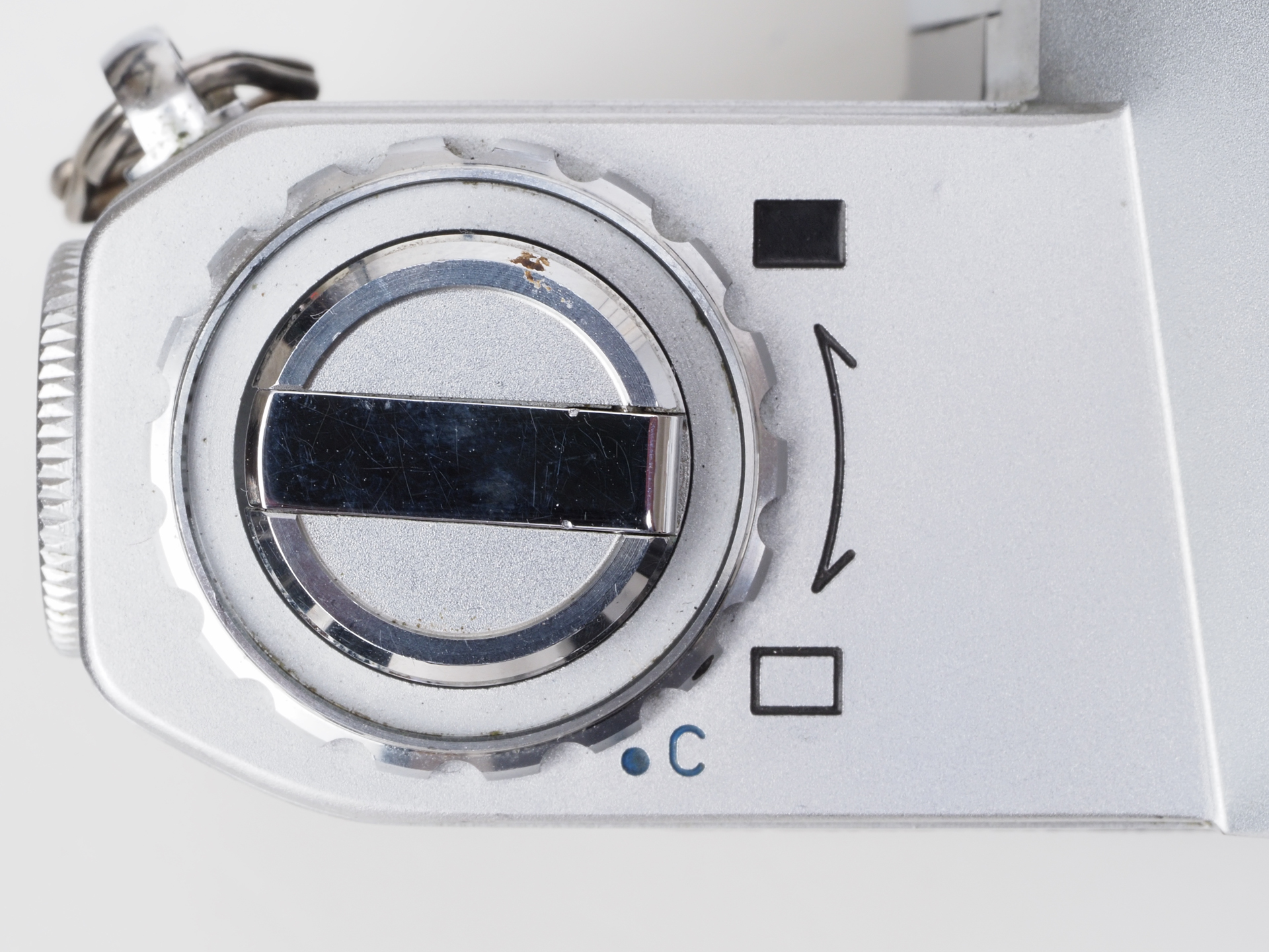 アイピースシャッター用のダイヤルです。フィルム巻き戻しクランクの基部にあります。アイコンがわかりやすい