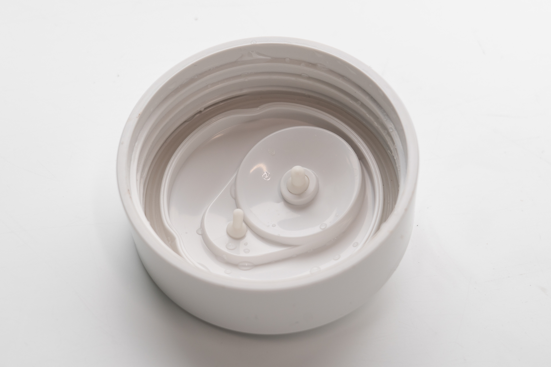 蓋を外して裏を見ると2つのピンが飛び出している。これは表に見える白いキャップの取り付け部分になるのだが、大きい方は蒸気逃しの穴であったのだ！ お湯を沸かす時は白いキャップを上から引き抜いて、蒸気を逃しながら使うべきであった。ああ、これは完全に僕の使用方法の誤りであった（笑）