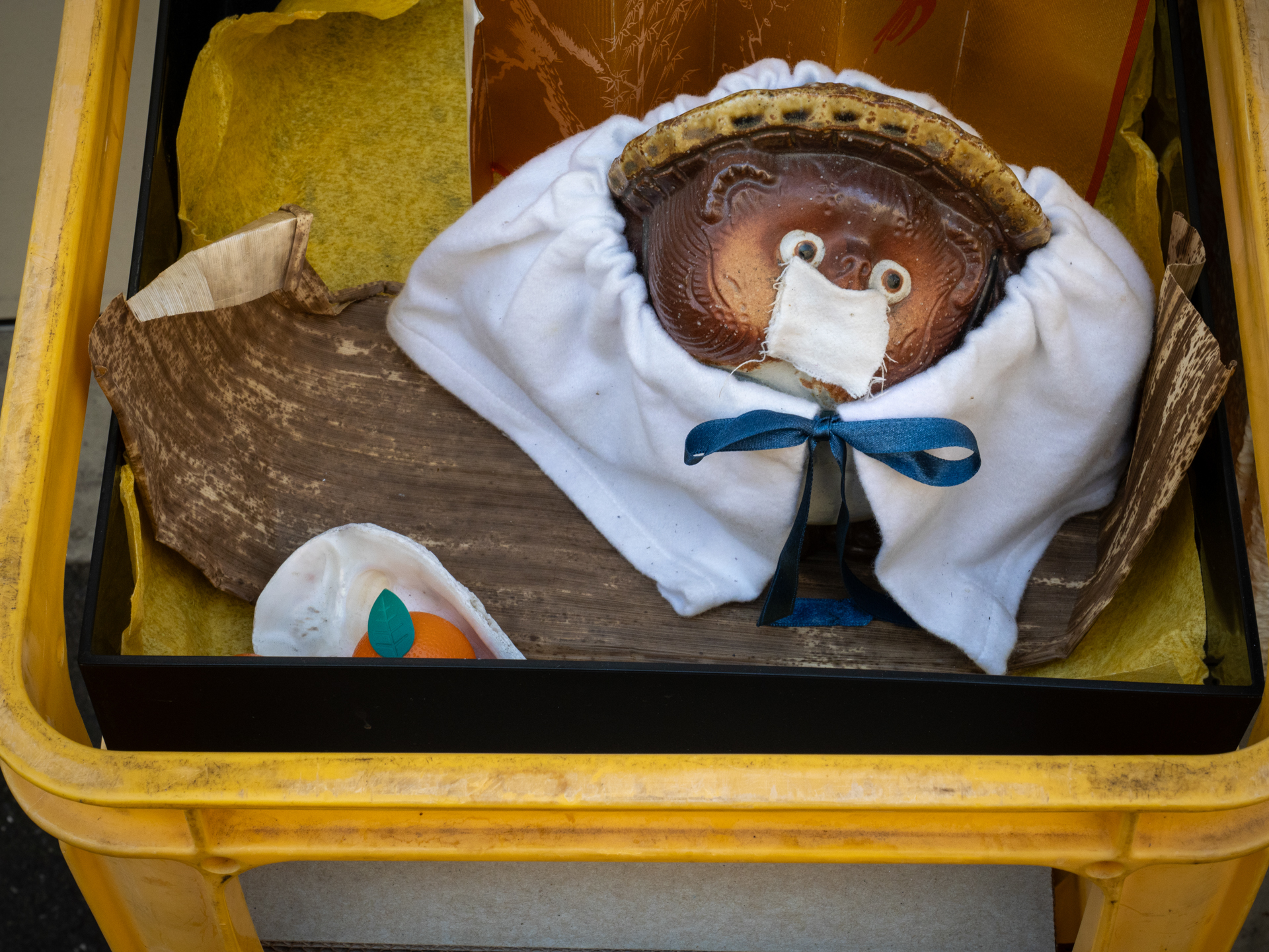 路地裏の、誘拐されたかのような猿ぐつわをされたタヌキの置物。12-60mmのズームって絶妙な焦点距離ですよね。他のレンズも携行したのですが、一度も交換しませんでした<br>LUMIX G9PROII／LEICA DG VARIO-ELMARIT 12-60mm / F2.8-4.0 ASPH. / POWER O.I.S.／プログラムAE（40mm・F11・1/80秒・-0.7EV）／ISO 400