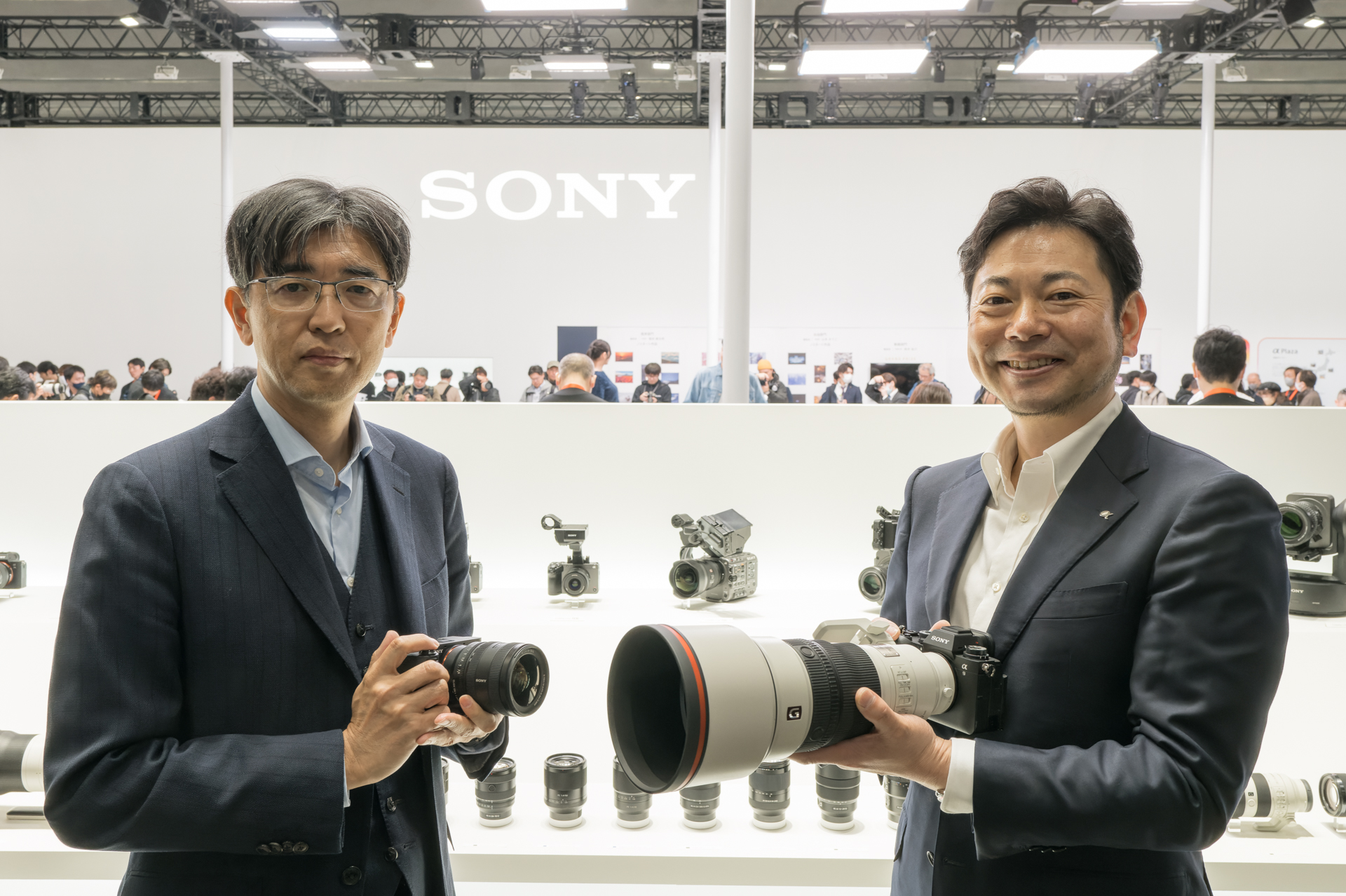 ソニー株式会社 イメージングエンタテインメント事業部 事業部長の大島正昭氏（右）、ソニー株式会社 レンズテクノロジー&システム事業部 事業部長の岸政典氏（左）。開場直後のソニーブースで話を聞いた
