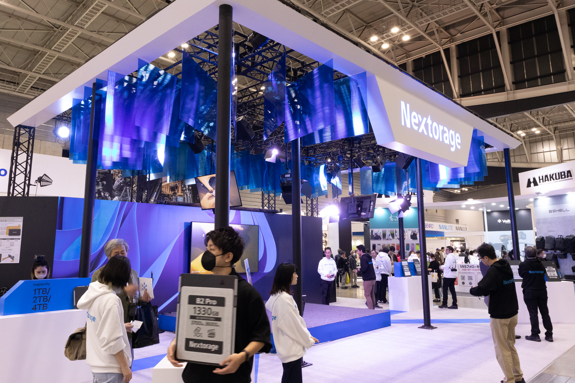 Nextorageはメモリーカードメーカーの中でも最大級のブースを構えていた。前回の2倍の広さという。天井に無数に設けられた青い板は連写をイメージしたもの
