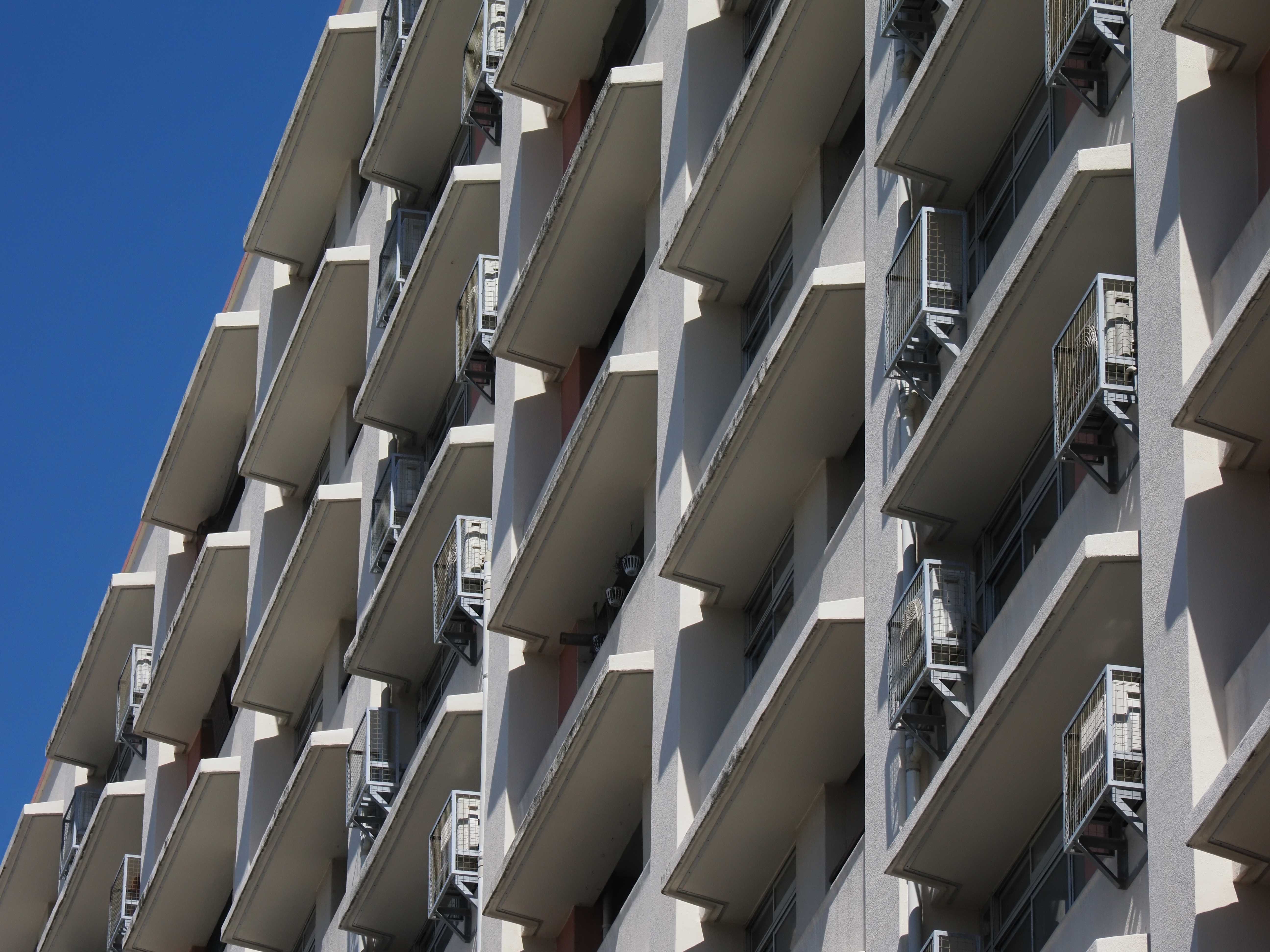 年季の入ったアパートを斜め下から。実は自動選択AFはどのあたりに合焦するか見てみたかったのですが、きちんとパンフォーカス撮影の基本である「画面の手前1/3」法則のところに合焦します。真面目です。実焦点距離が短く被写界深度が深いので望遠でもパンフォーカスになります<br><span class="fnt-85">OM-1 Mark II／M.ZUIKO DIGITAL ED 12-100mm F4.0 IS PRO／100mm（200mm相当）／絞り優先AE（1/2,000秒、F10、−0.3EV）／ISO 800</span>