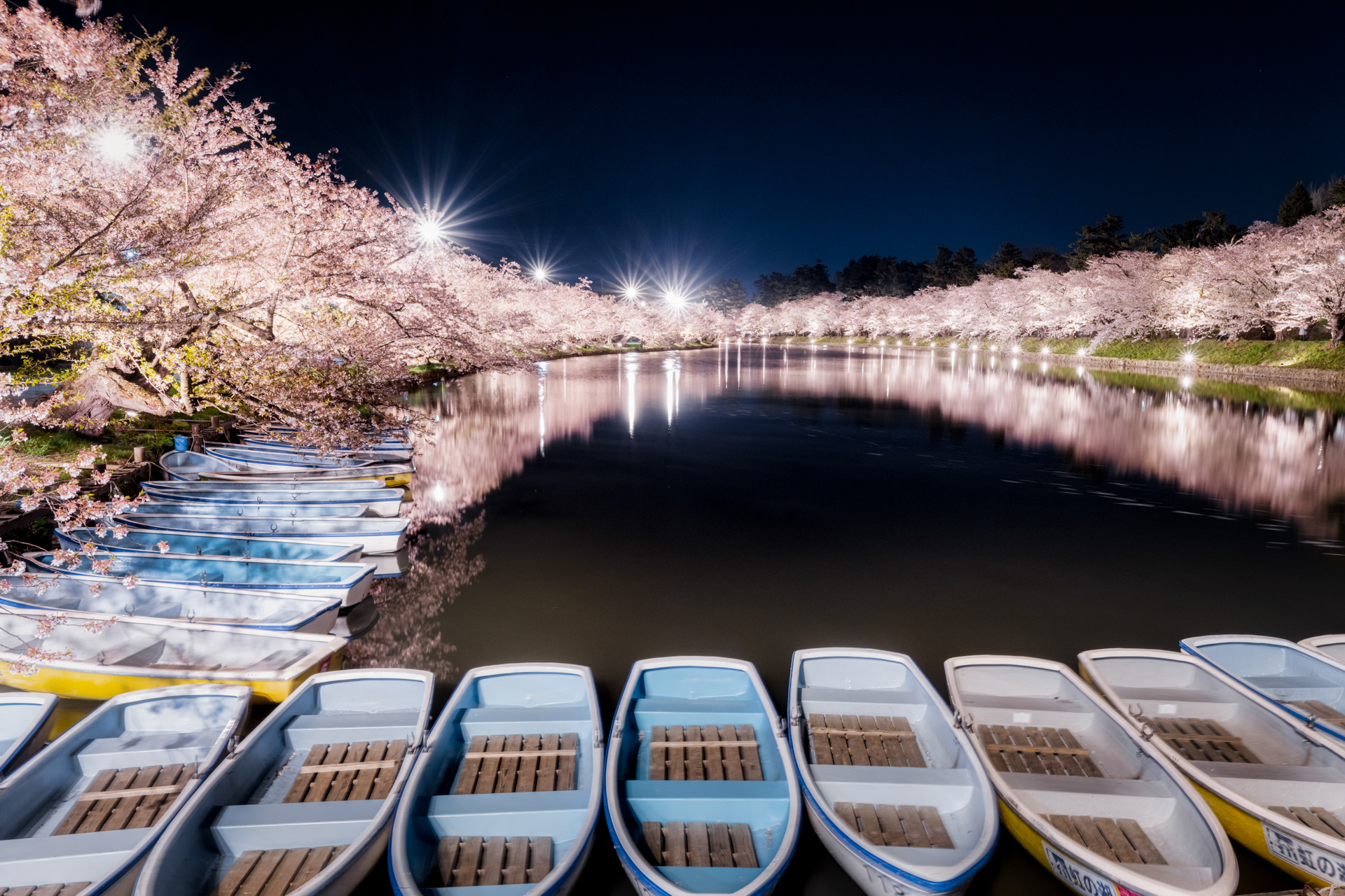 お堀の周りを探索中、それまでの強風がぴたりと止んだ。水面に映る桜と止まったボートが輪を描き、光芒がアクセントになり、静かなリズムを奏でている<br><span class="fnt-85">Z 7 II／NIKKOR Z 14-24mm f/2.8 S／24mm／マニュアル（8秒、F13）／ISO 160</span>