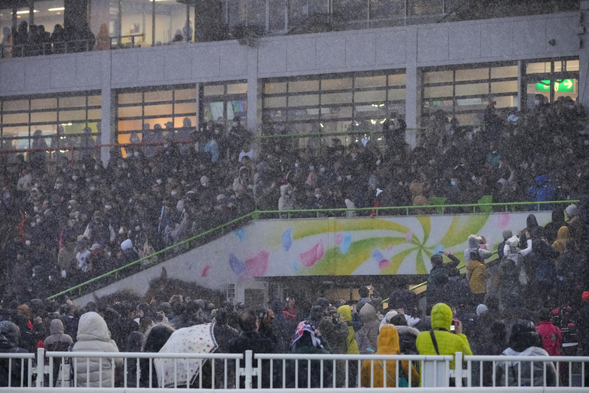 雪が降ってもほとんどの人が傘をささずレースを見守る