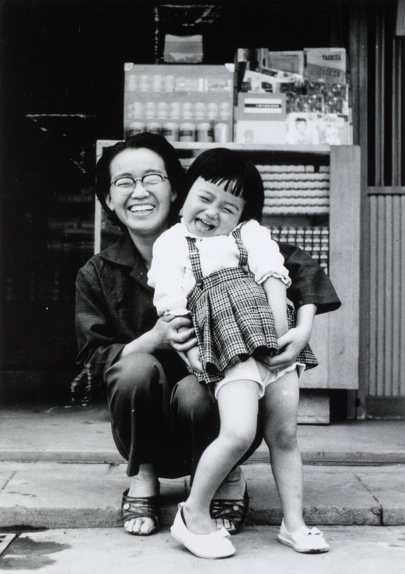 タイトル：なつかしき昭和30年代写真屋さんの店頭（フィルムの箱の前）／出展者のメッセージ：63年前の私と母です。父が撮りました