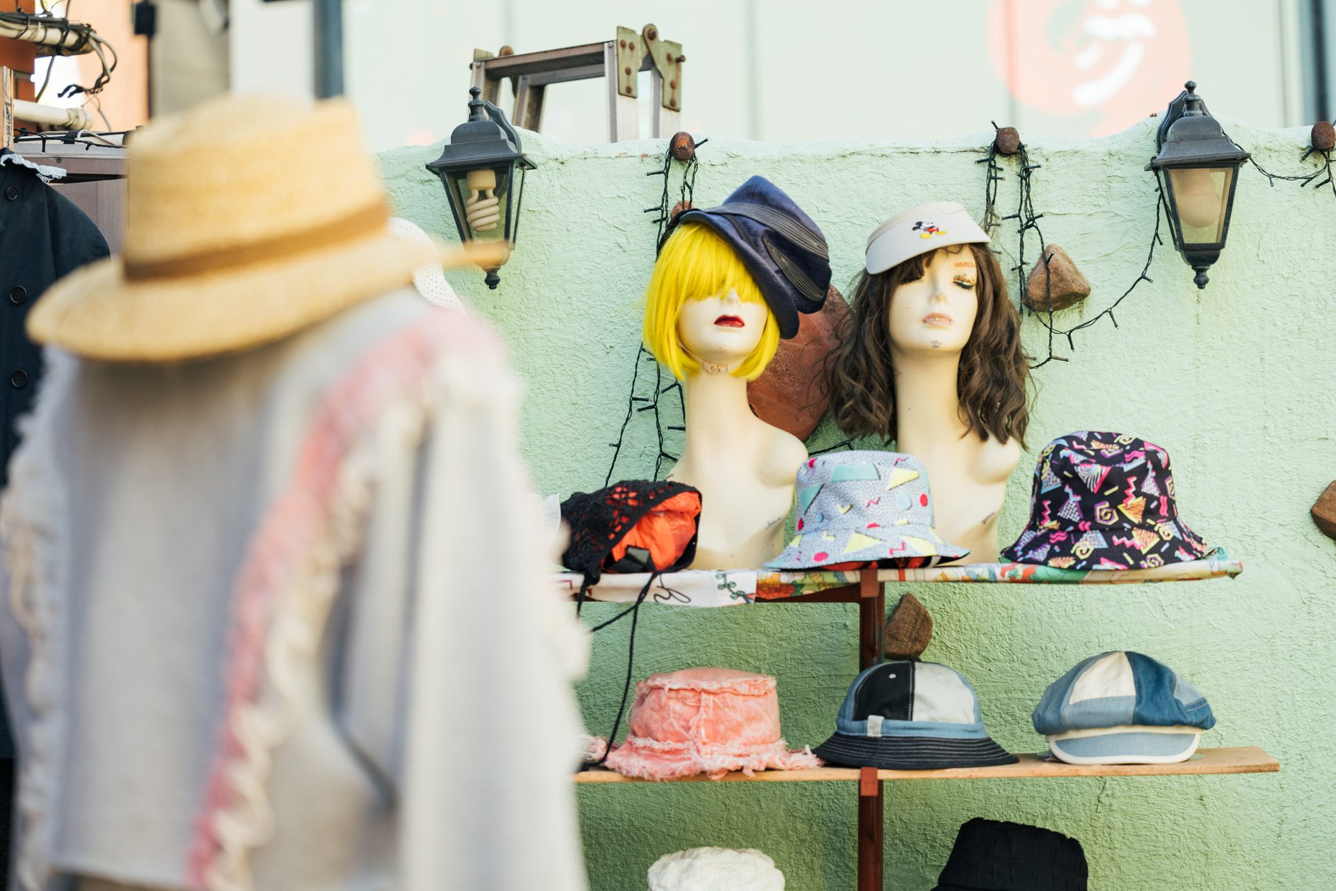 100mmの圧縮効果で帽子屋のディスプレイのにぎやかさを1枚に詰め込んだ。絞りは開放にして、前ボケで奥行きを加えている。雑多な街中では中望遠レンズを使うと絵作りしやすい<br><span class="fnt-85">キヤノン EOS R8／RF100mm F2.8 L MACRO IS USM／100mm／絞り優先AE（F2.8、1/640秒、＋0.7EV）／ISO 200／WB：6,200K（B2＋G2）</span>